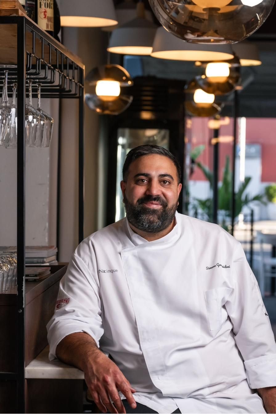 Lo chef in giacca bianca seduto al ristorante