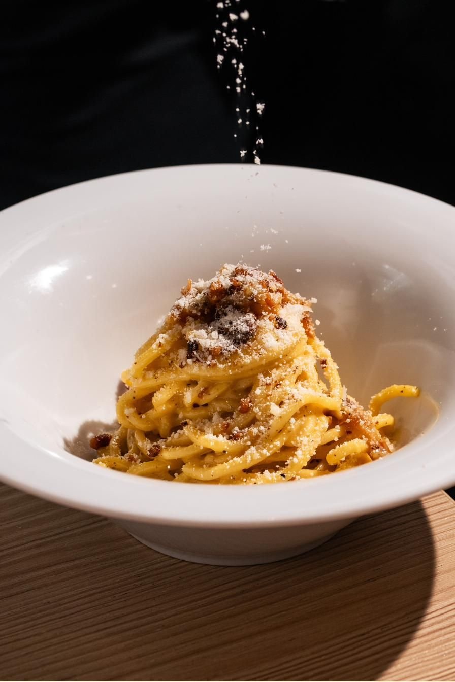 Piatto di spaghetti con guanciale e pecorino in una fondina bianca